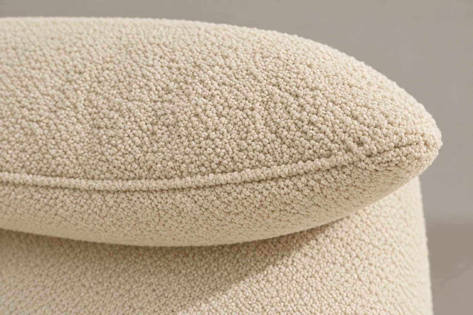 Подушка-подголовник, сложенная вперёд через верхнюю кромку спинки, в молочном букле