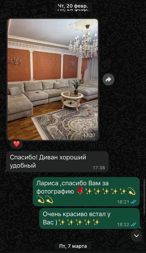 Длинный светло-бежевый модульный диван в классической гостиной с люстрой, терракотовыми стенами и ковром