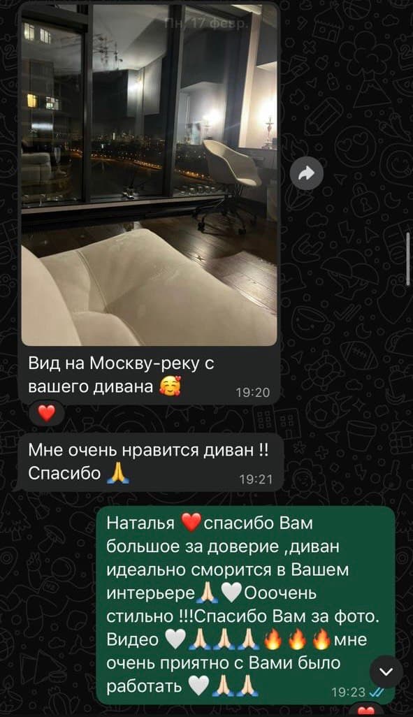 Молочный диван у панорамного окна с ночным видом на Москва-реку и набережную
